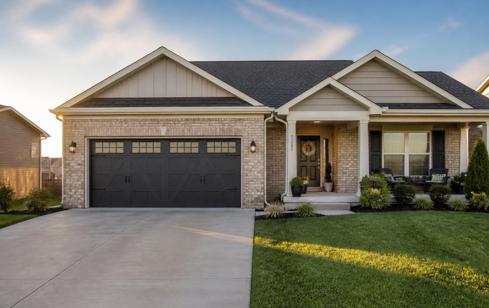 Charcoal carriage-style garage door installed on a brick home in Overland Park, Kansas